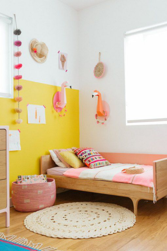 Gelbe Akzentwand im Interieur Mädchenzimmer leuchtendes Gelb mit rosafarbenen Accessoires und Deko