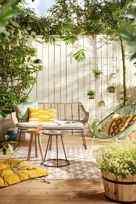 Veranda frühlingshaft gestalten einfache Gartenmöbel fröhliche Farben Sitzkissen viel Grün eine Wohlfühloase schaffen