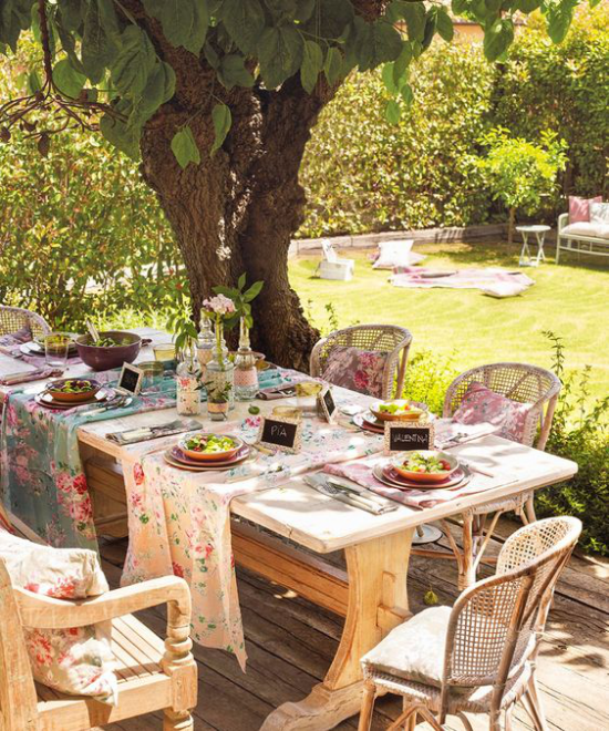Veranda frühlingshaft gestalten festlich gedeckter Tisch draußen gute Stimmung fröhliche Farben florale Muster das Hellgrün des Rasens