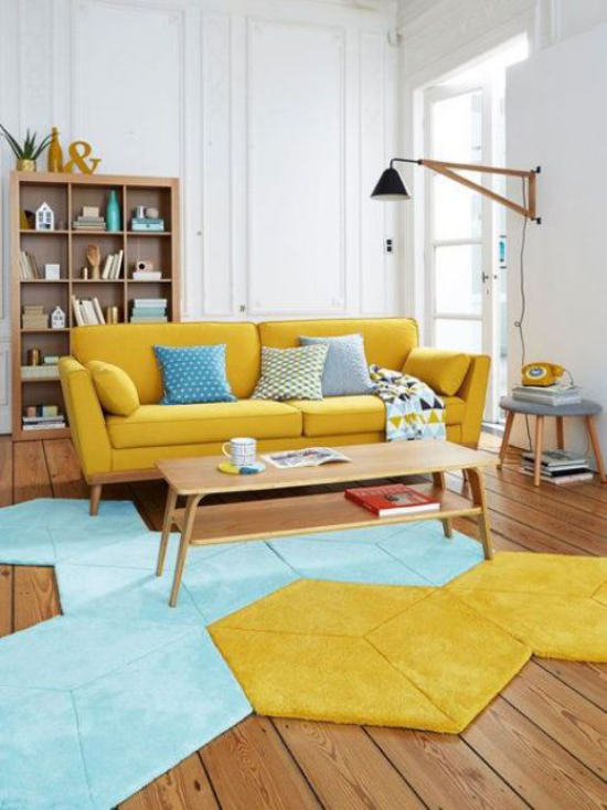 leuchtendes Gelb im Wohnzimmer gelber Sofa interessanter Teppich in Gelb und Hellblau
