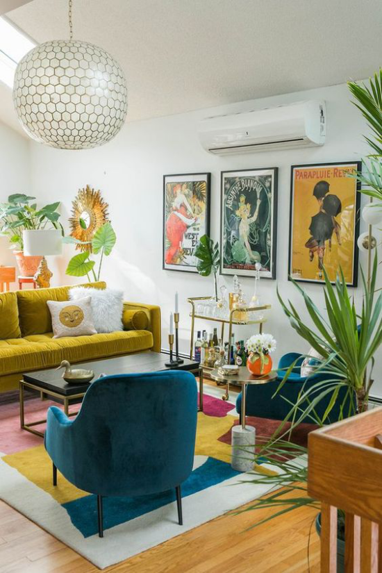 leuchtendes Gelb im Wohnzimmer viele Farben sich komplementieren Gemälde an der Wand Grünpflanzen