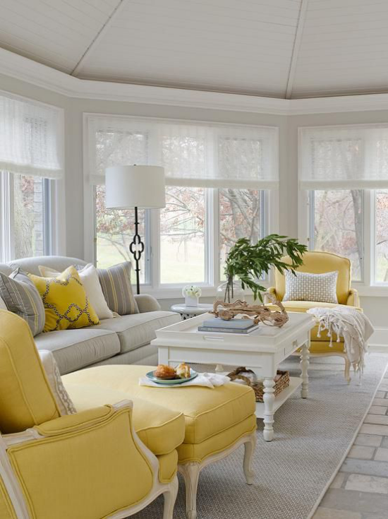 leuchtendes Gelb im Wohnzimmer weiter heller Raum klassische Möbel Hellgrau und Zitronengelb dominieren weite Fenster