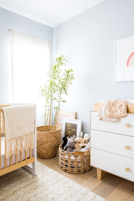 Babyzimmer Trends 2021 Wandfarbe Pastellblau helles Ambiente Korb aus Rattan Spielsachen Topfpflanze
