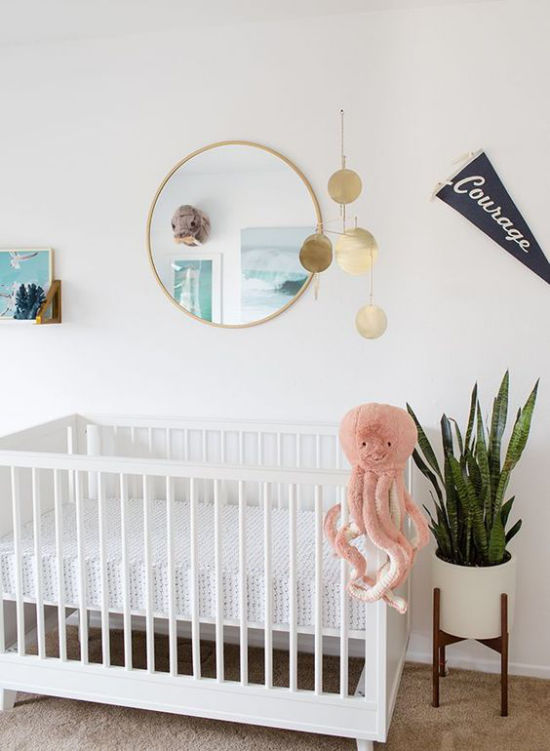 Babyzimmer Trends 2021 weißes Bett runder Spiegel Spielzeug Oktopode Urlaubsfeeling