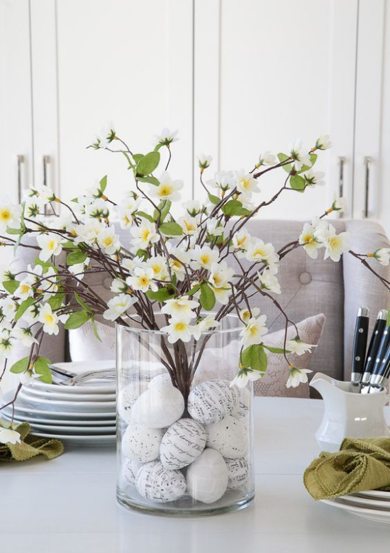 Frühlingshafte Tischdeko bemalte Eier Glasgefäß schöne blühende Zweige Blickfang