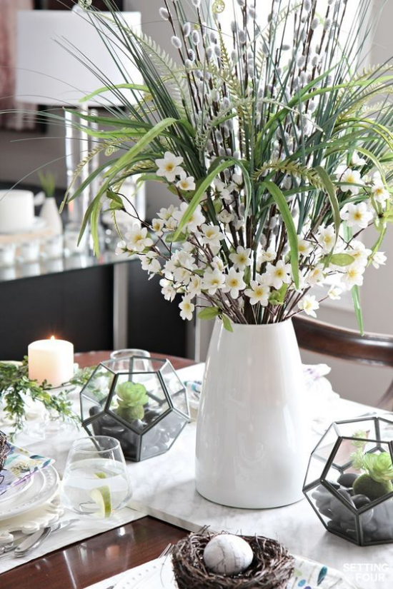 Frühlingshafte Tischdeko ein Osternest weiße Vasen mit Narzissen Blickfang festlich gedeckter Tisch