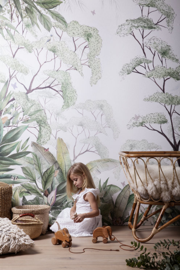 Kunstvolle Fototapeten Akzentwand Kinderzimmer tropisches Muster gemütliche Raumatmosphäre kleines Mädchen spielt