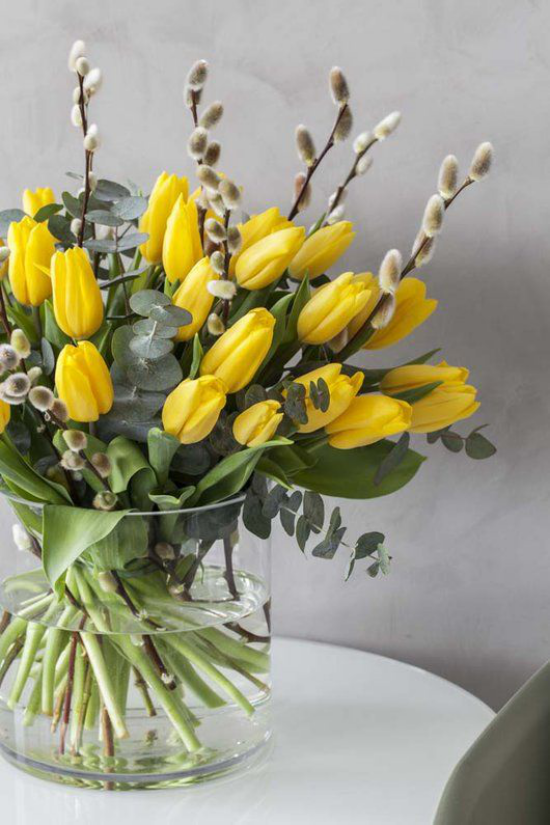 Schöne Blumenarrangements Glasgefäß gelbe Tulpen arrangiert Weidenkätzchen