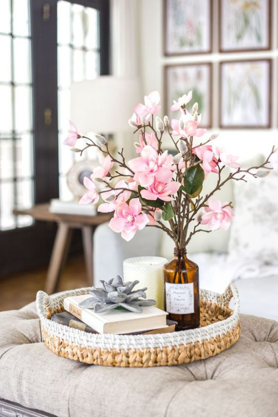 Schöne Blumenarrangements alte Flasche aus dunklem Glas Kirschzweige rosa Blüten Blickfang im Wohnzimmer