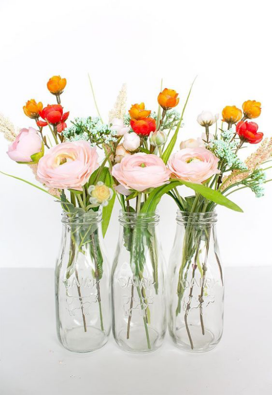 Schöne Blumenarrangements drei Glasflaschen rosafarbene Päonien Kräutergräser