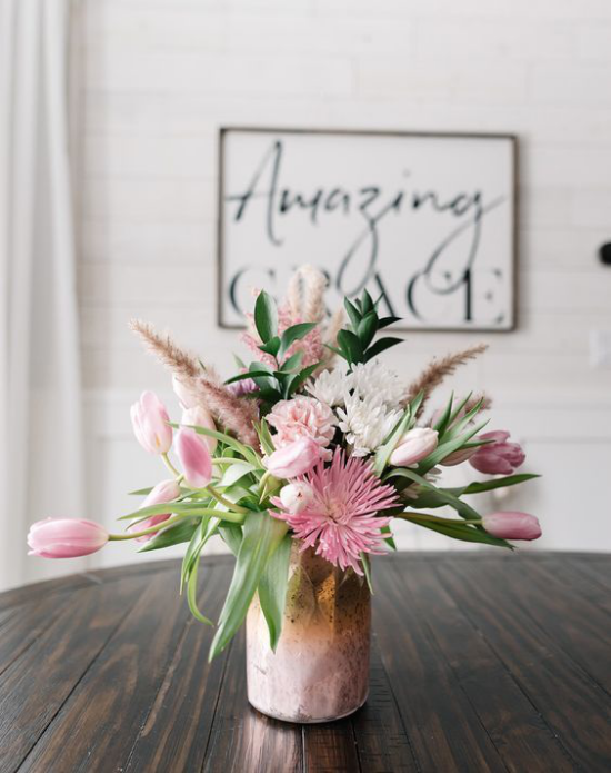 Schöne Blumenarrangements rosafarbene Tulpen und andere Blumen im Metallgefäß kleine Vase