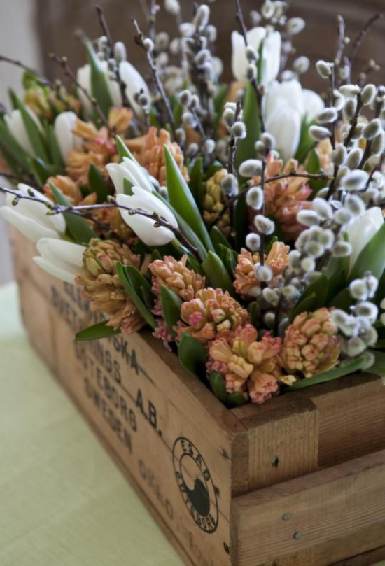 Schöne Blumenarrangements rustikales Arrangement im Holzkasten orangene Hyazinthen weiße Tulpen Weidenkätzchen