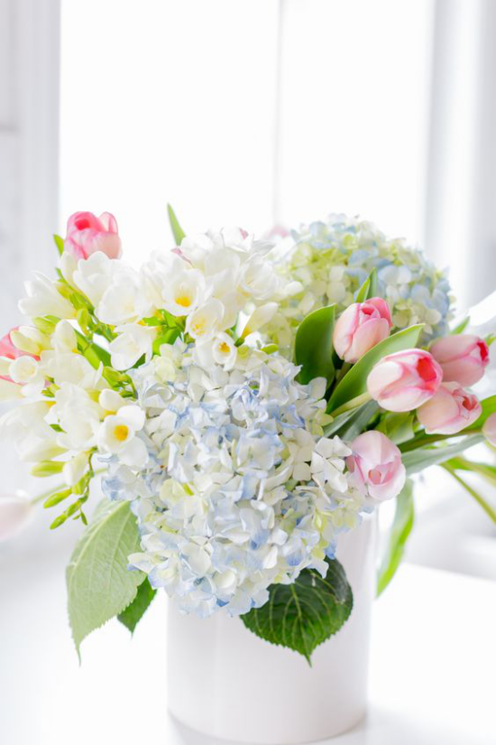 Schöne Blumenarrangements weiße Vase Hortensien Narzissen Tulpen in Pastelltönen