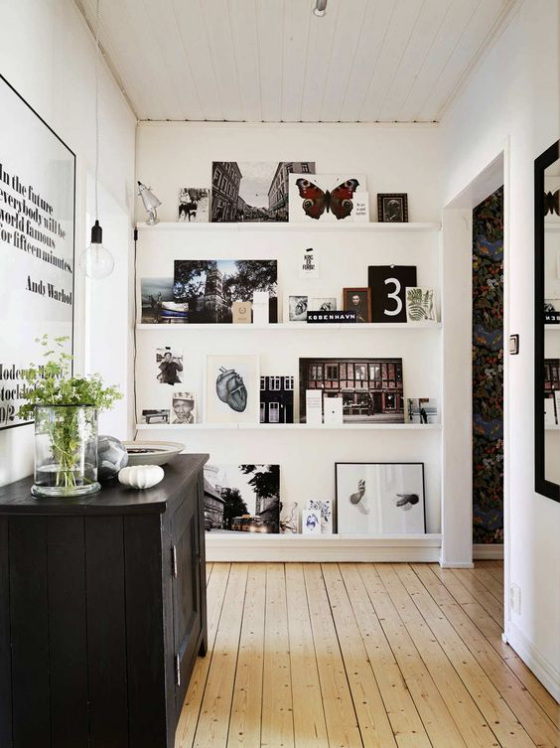 Fotowand auf Leisten Holzboden Wandgestaltung in schwarz weiß Blickfang schwarze Kommode links