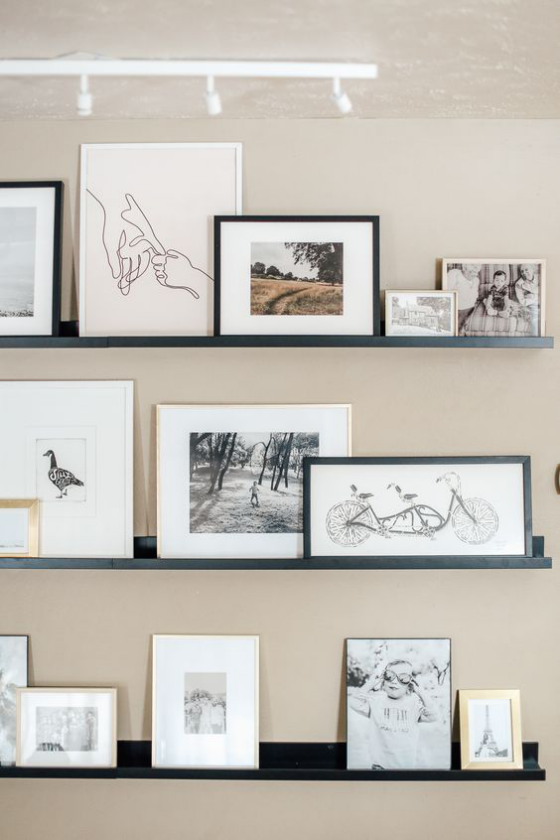 Fotowand auf Leisten im Wohnzimmer clever arrangiert schöne Bilder zur Schau stellen