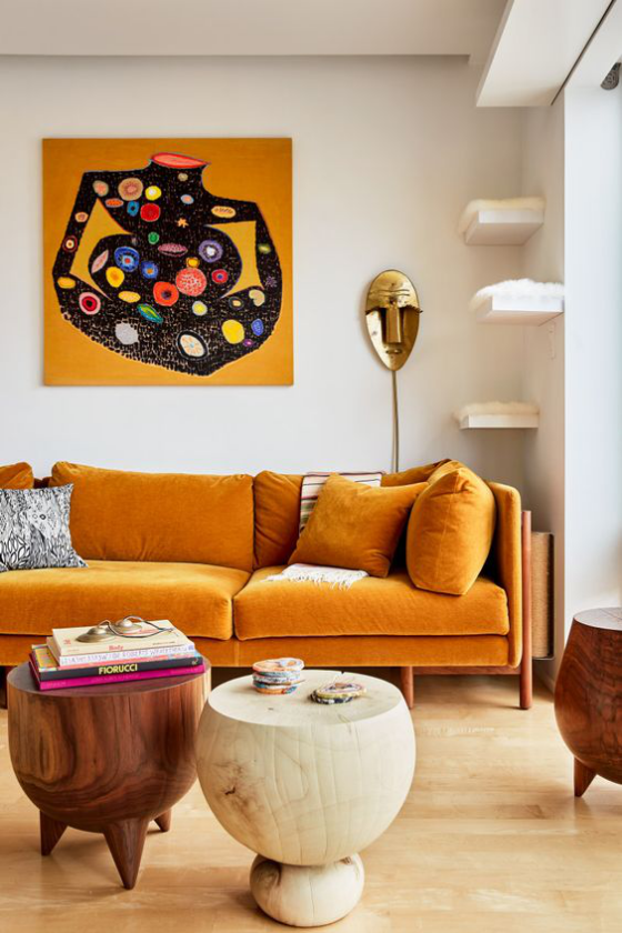 Gelbes Sofa buntes sehr auffälliges Wohnzimmer Bild über dem Sofa runde Hocker aus Holz als Tische verwendet