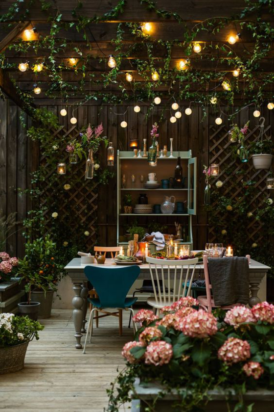 Gartenbeleuchtung Esstisch Abendessen im Freien viele Lichter Hortensien im Vordergrund