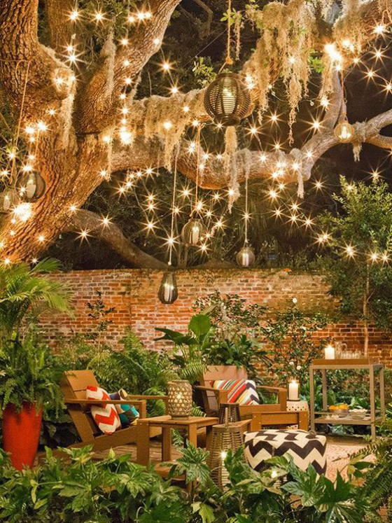 Gartenbeleuchtung märchenhafte Atmosphäre abends im Freien Sitzecke unter dem Baum Lichterketten