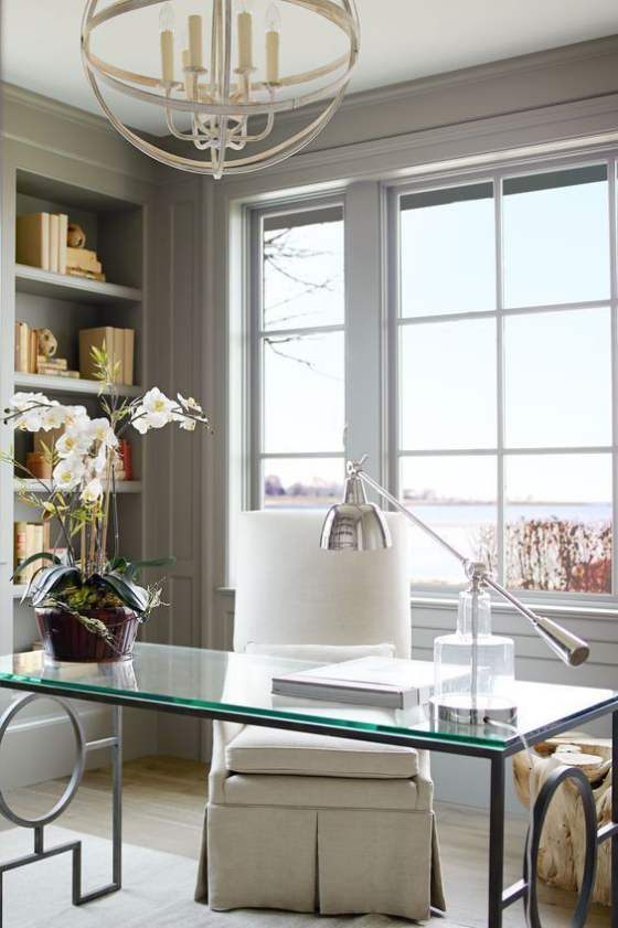 Home Office Design Ideen Glastisch perfekt designter Raum Fenster eingebaute Bücherwand weiße Orchideen auf dem Tisch als Deko