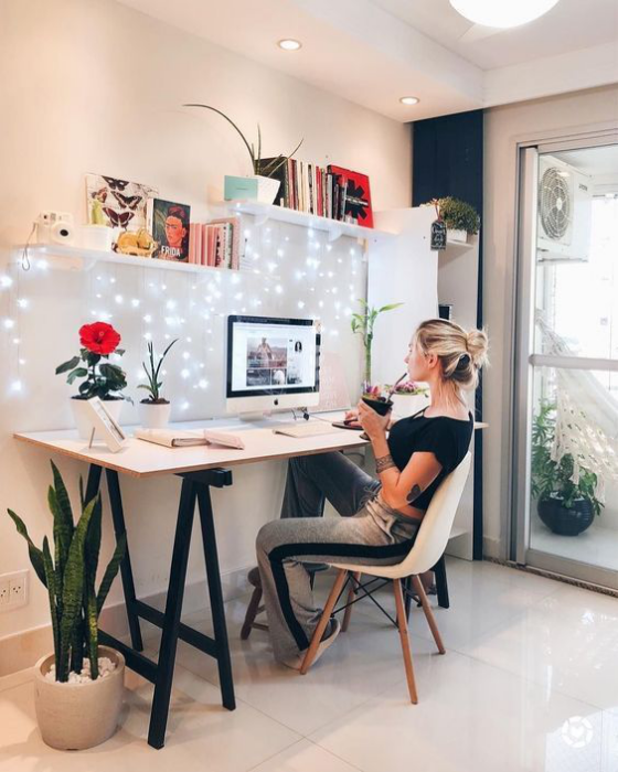 Home Office Design Ideen junges Mädchen arbeitet vor dem PC Akzentwand Lichterketten schönes Design Regale