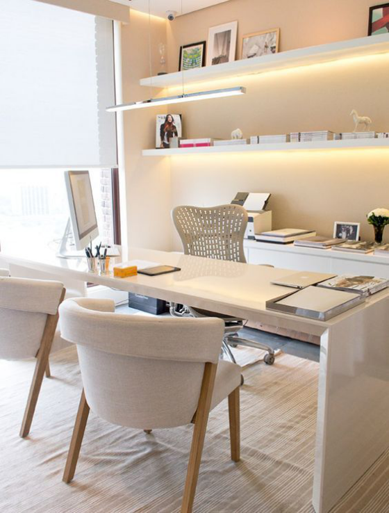 Home Office Design Ideen modern eingerichtetes Heimbüro weiße Sessel Schreibtisch eingebaute LED Beleuchtung Regale