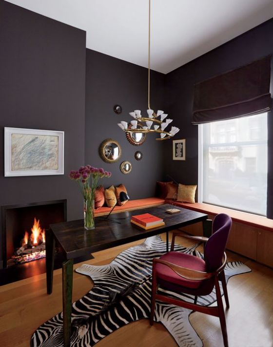 Home Office Design Ideen sehr stilvoll gestalteter Raum Kamin Schreibtisch Stuhl dunkle Wände Teppich in Tigerfellmuster rote Akzente