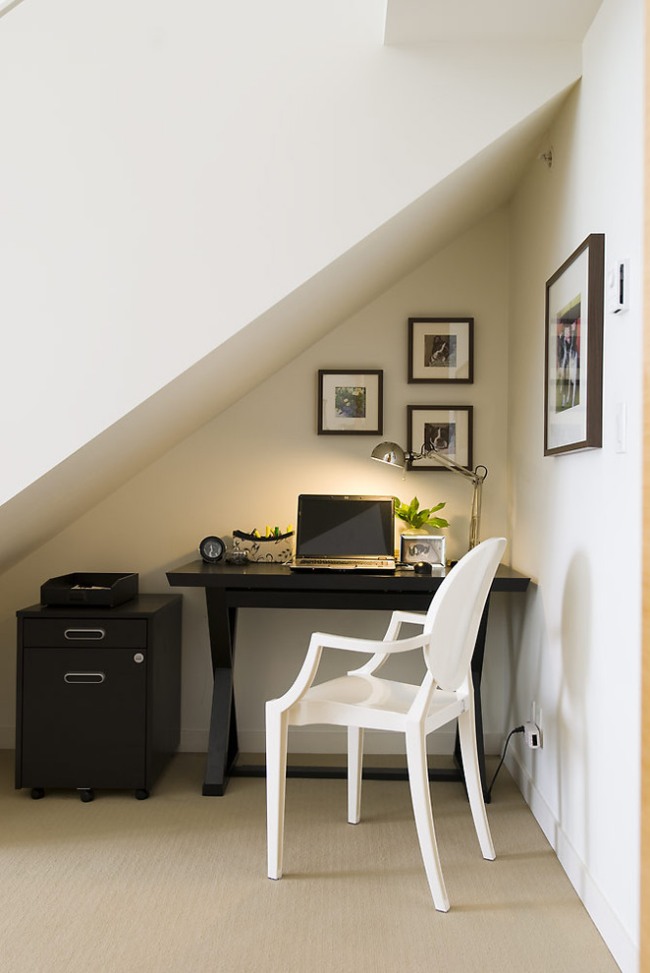 Kleines Home Office unter der Treppe fast kein Tageslicht Tischlampe schattenliebende Topfpflanze etwas Grün neben PC Bilder an der Wand