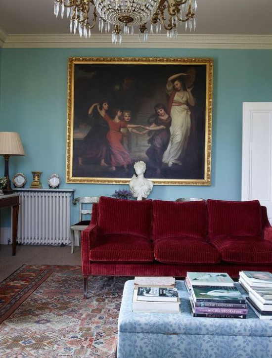 Rotes Sofa Ambiente im Retro Stil dunkelrotes Sofa Wandbild Kronleuchter Teppich