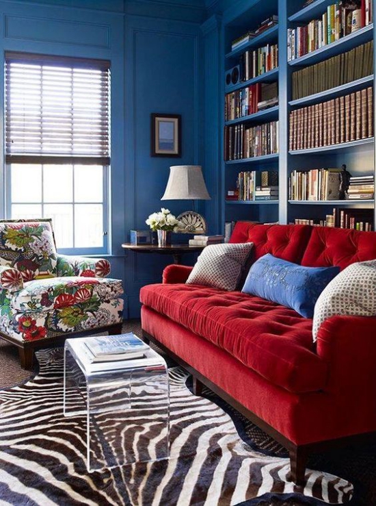 Rotes Sofa Fell Teppich Plastiktisch bunter Sessel blaue Wände ausgefallenes Raumdesign