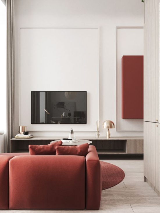 Rotes Sofa schickes modernes Interieur dezente Rotnuance klassisch sehr gehoben Fernseher helle Wände Lampe