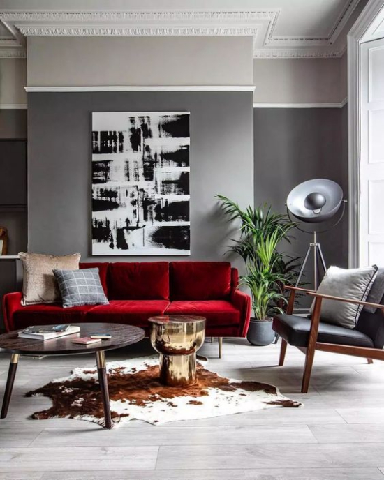 Rotes Sofa stilvolles Raumdesign graue Wand grauer Ledersessel Wanddekoration Teppich