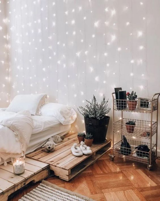 Teenager Zimmer niedriges Bett auf Paletten Lichterketten an der Wand Holzboden Blumenregal aus Metall