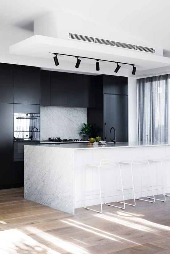 kontrastierende Kücheninsel aus weißem Marmor sehr moderne Küchengestaltung Kontrast mit den schwarzen Küchenschränken eingebaute Küchengeräte