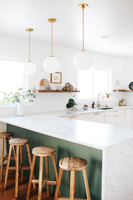 kontrastierende Kücheninsel die Marmorplatte erfrischt das Küchendesign viel Tageslicht Holzhocker im Vordergrund