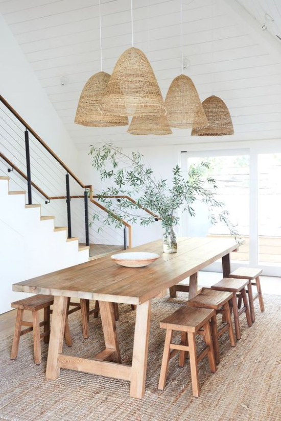 Esszimmer in neutralen Farben viel Holz vielfältig einsetzbar großer Esstisch Stühle aus Naturholz Hanf Teppich geflochtene Hängelampen einladendes Ambiente Treppe