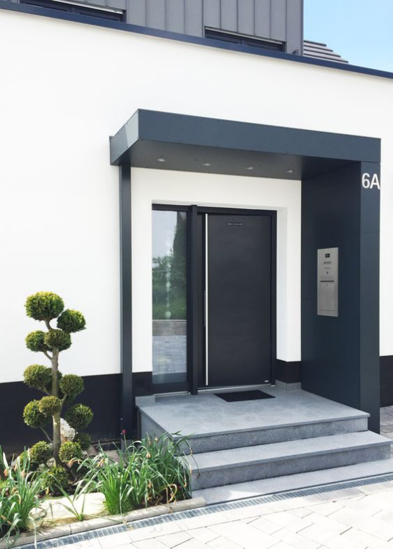 modern und minimalistisch - elegante schwarze Haustür mit grauer Betontreppe 