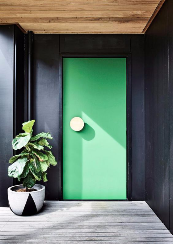  hellgrüne Tür links daneben ein Topf mit Grünpflanze 