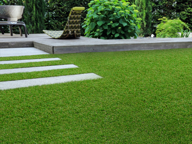 Kunstrasen schöner gepflegter Außenbereich künstliche Rasenfläche Steinplatten Sitzecke