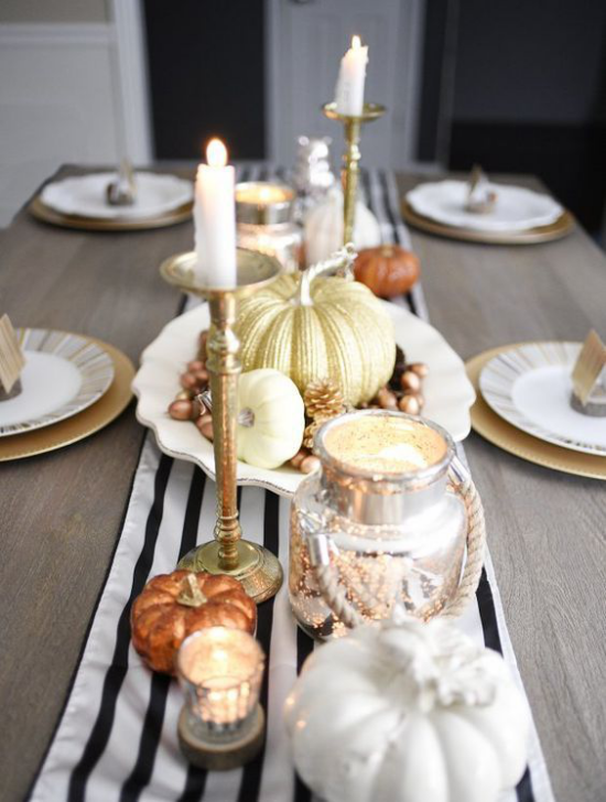 Herbstdeko auf dem Esstisch elegantes Arrangement gestreifter Tischlaufer Kerzenstander Kerzen Kurbisse