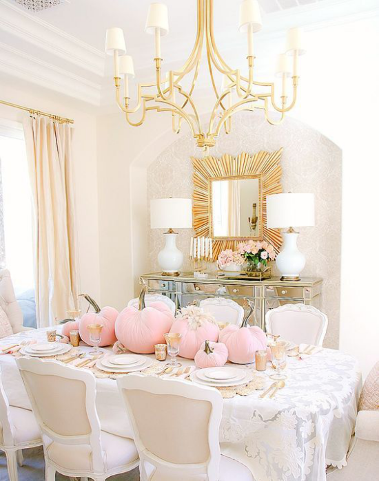 Herbstdeko auf dem Esstisch romantische Extravagant rosafarbene Kurbisse viel Goldglanz Spiegel Besteck Kronleuchter zwei Lampen feine weise Tischdecke
