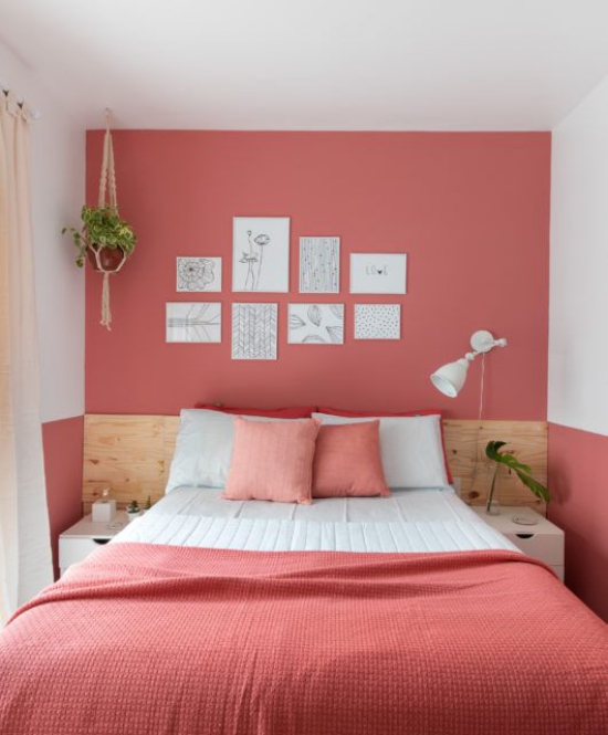 Rosa Akzentwand Lachsrosa im einfach eingerichteten Schlafzimmer bringt den Raum zum Leuchten