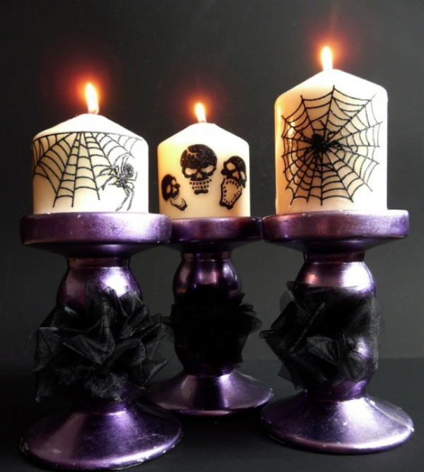 Halloween Deko in Lila drei lila Kerzenstander weise Kerzen mit gruseligen Elementen geschmuckt