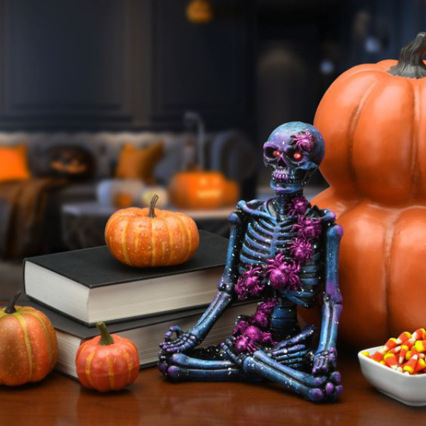 Halloween Deko in Lila orangefarbene Kurbisse ein lila schwarzes Skelett daneben