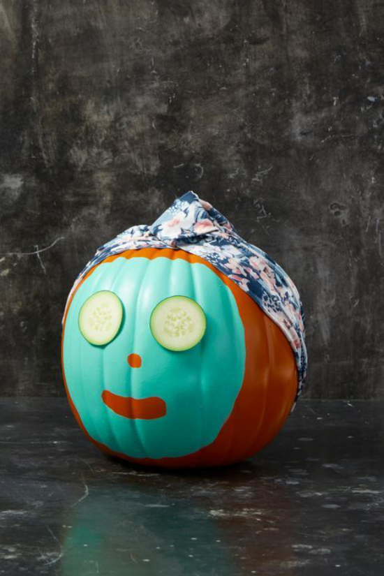 Halloween Deko mit Kurbissen lustig geschmuckter Kurbis mit Gesichtsmaske Gurkenscheiben Kopfbedeckung