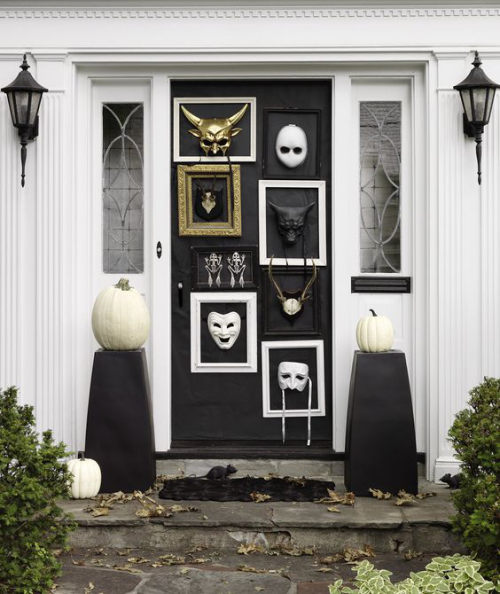 Halloween Deko vor der Haustur stilvoll gestaltet schwarze Haustur Bilderrahmen Masken in Weis und Gold