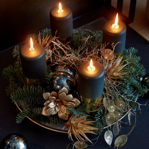 Adventskranz ein Must have der Vorweihnachtszeit dunkelblaue Kerzen brennen Tannengrun goldgelber Schmuck Glanz und Glamour