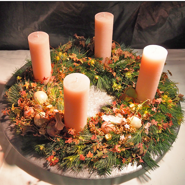 Adventskranz ein Must have der Vorweihnachtszeit in warmen Herbstfarben gestaltet orangefarbene Kerzen Tannengrun buntes Laub