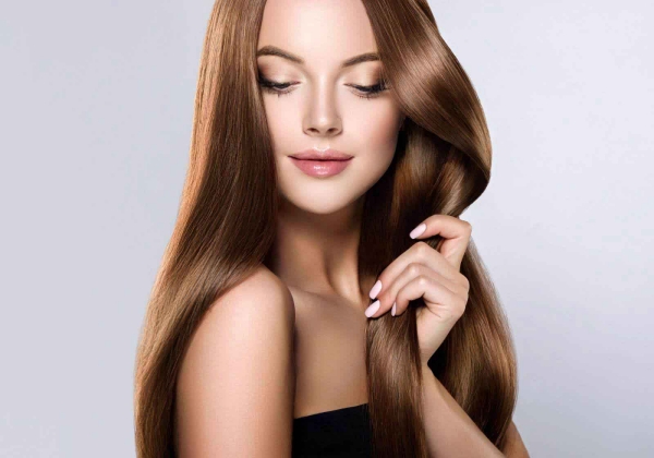 junge Frau trägt schönes langes glänzendes Haar dank richtiger Haarpflege