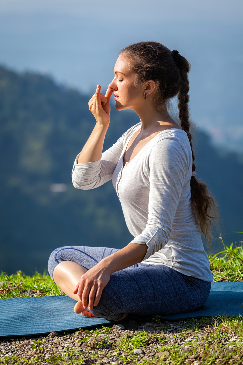 Junge Frau praktiziert Yoga im Gebirge