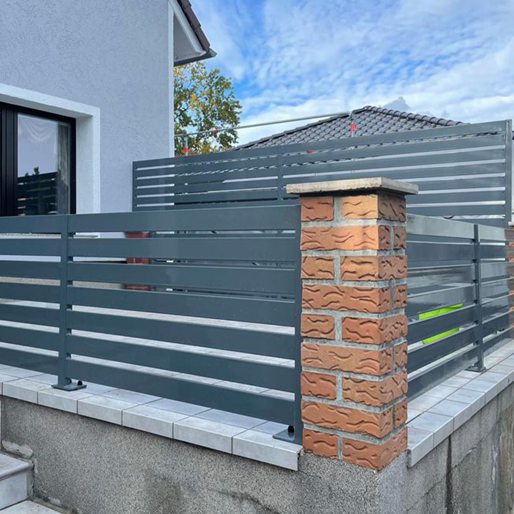 moderner Zaun aus Betonmauer und Aluminiumpaneelen